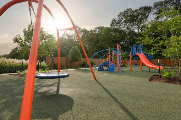 a playground with slides and other toys in a park at The Village at Caney Mills, Texas, 77303