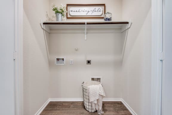 a laundry room with a basket and a shelf on the wall