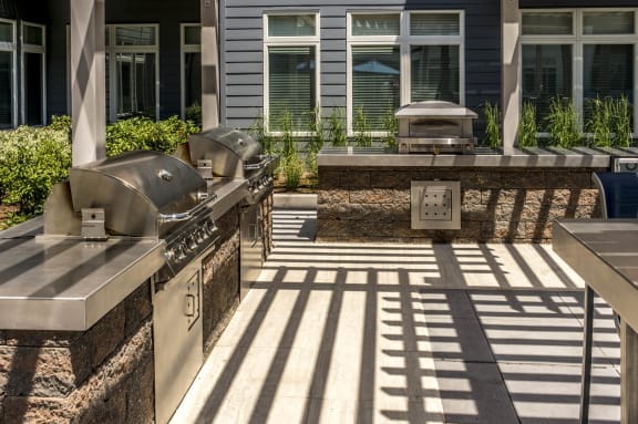a covered patio with a grill and a barbecue