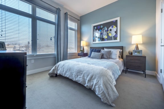 a bedroom with a bed and two windows