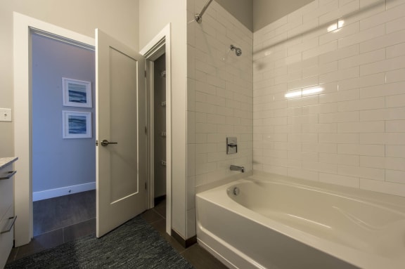 a bathroom with a tub and a shower and a door