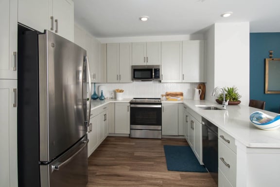 a kitchen with white cabinets and stainless steel appliances