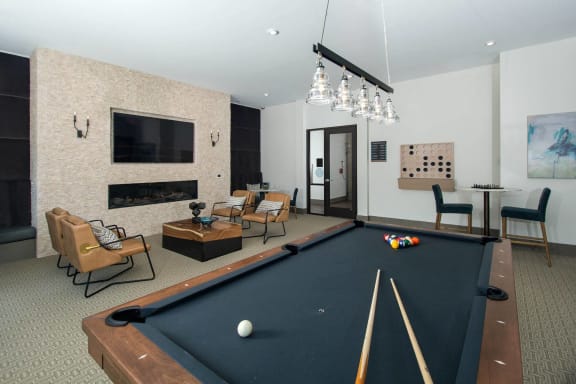 a games room with a pool table and a television
