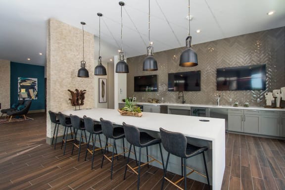 a large kitchen with a white counter top and chairs
