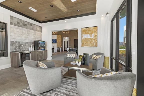 a living room with couches and chairs and a kitchen