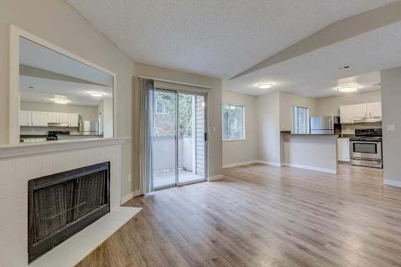 A spacious living room with a fireplace and sliding glass doors.