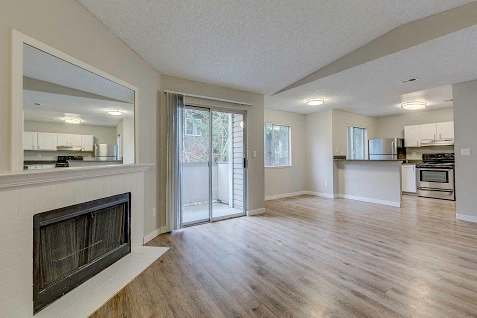 A spacious living room with a fireplace and sliding glass doors.