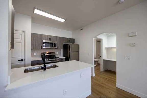 A kitchen with a white counter top and a sink.