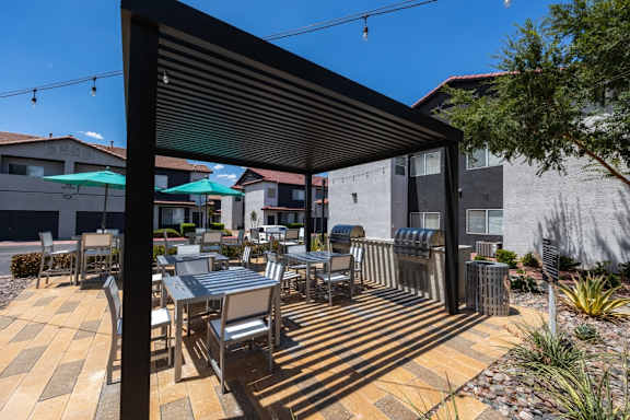 A patio with a table and chairs under a black awning.
