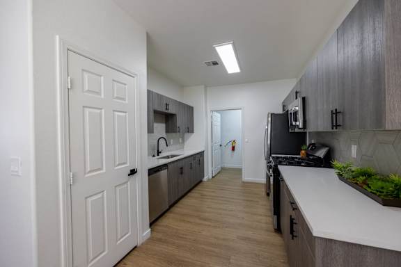 A kitchen with a white door and a black fridge.