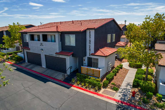 A two-story house with a red roof and a garage.