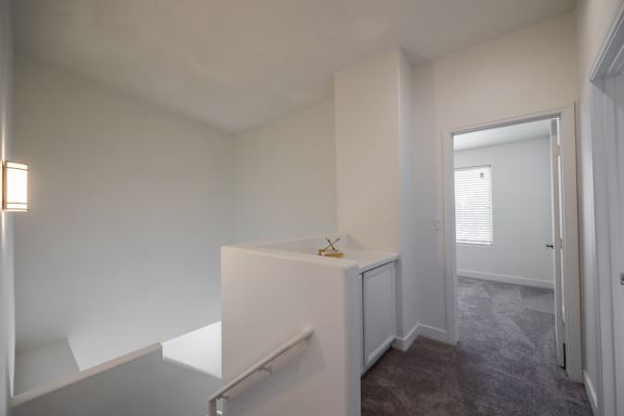 A white cabinet with a small yellow object on top is in a room with a carpeted floor.