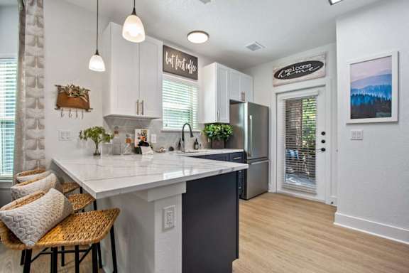 A kitchen with a white counter top and a refrigerator.
