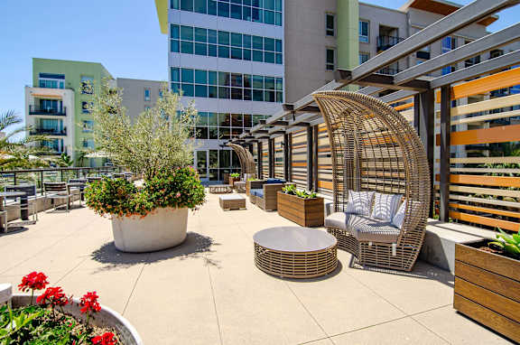 A patio area with a wicker chair and table.