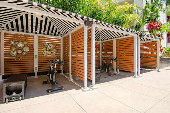 A gym with exercise equipment and a zebra print ceiling.