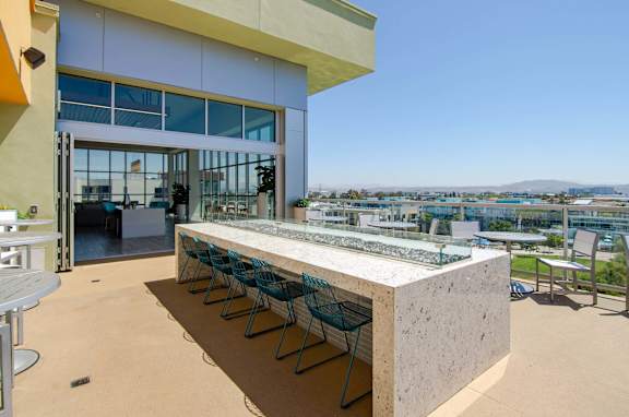 A patio with a table and chairs overlooking a cityscape.