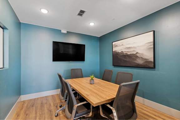 A conference room with a wooden table and chairs.