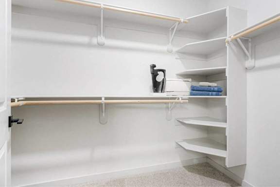 A white closet with a towel on the shelf.