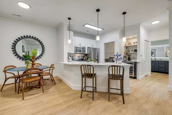 A kitchen with a table and chairs.