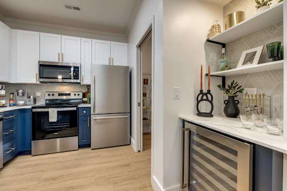 A kitchen with a refrigerator, oven, and microwave.