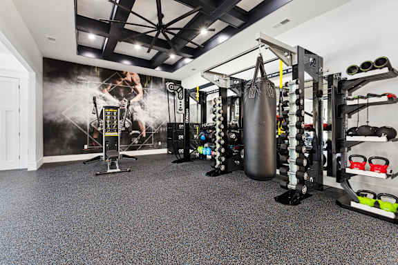 A gym with a punching bag, weights, and exercise equipment.