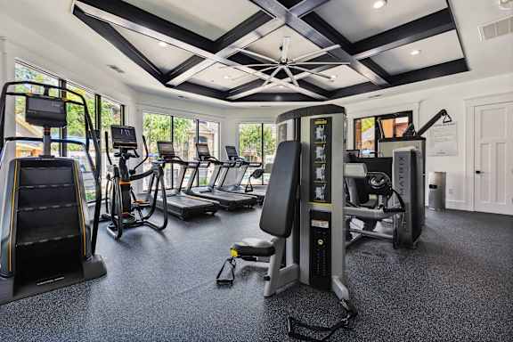 A gym with a variety of equipment including treadmills, stationary bikes, and weight machines.