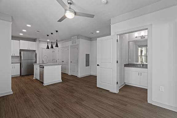 A kitchen with white cabinets and a ceiling fan.