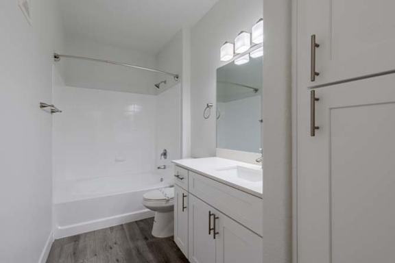 A white bathroom with a toilet, sink, and tub.