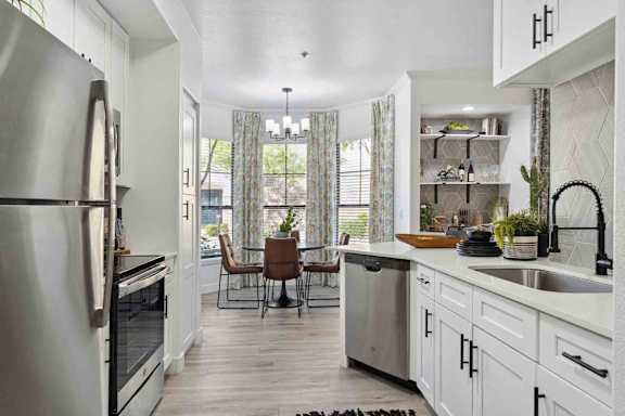 A modern kitchen with a dining table and chairs.