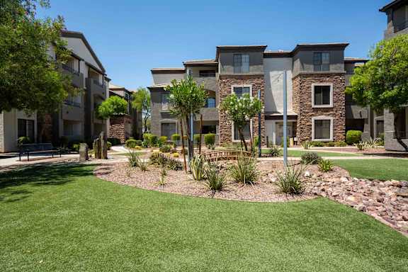 A row of modern houses with a well-maintained lawn in front.