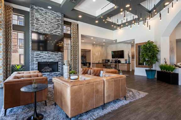 A modern living room with a stone fireplace and a large sectional sofa.