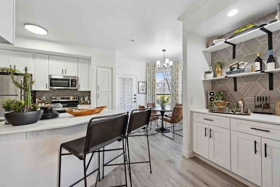 A modern kitchen with a dining table and chairs.