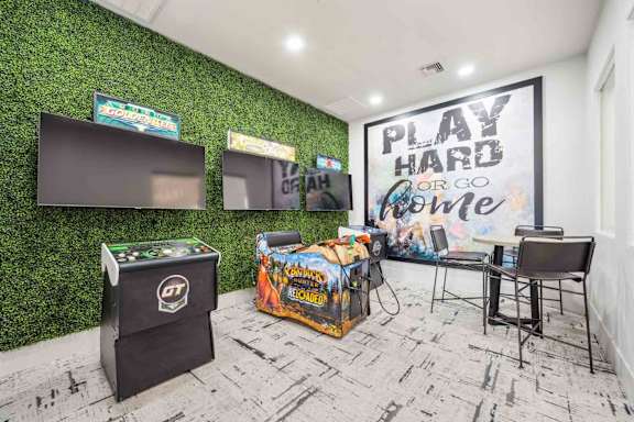 A room with a green wall and a sign that says "PLAY HARD OR GO HOME".