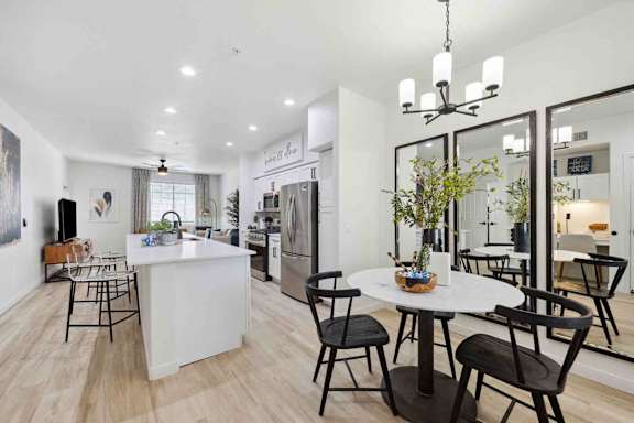 A modern kitchen with a dining table set for four.