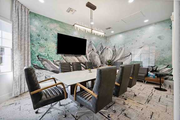 A conference room with a large table and chairs.
