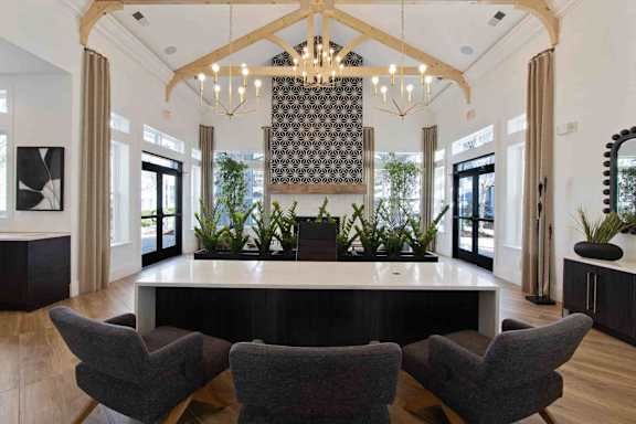 A large, elegant room with a long table and chairs, a chandelier, and a large mirror on the wall.
