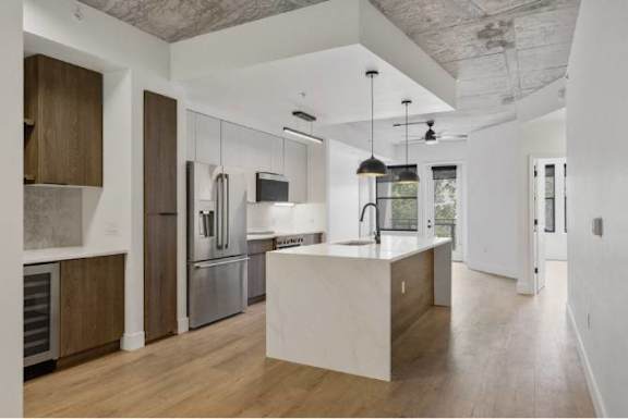 A modern kitchen with a white island and stainless steel appliances.