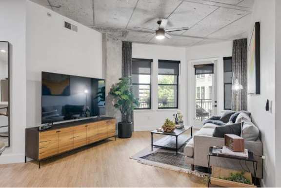 A modern living room with a flat screen TV and a wooden cabinet.