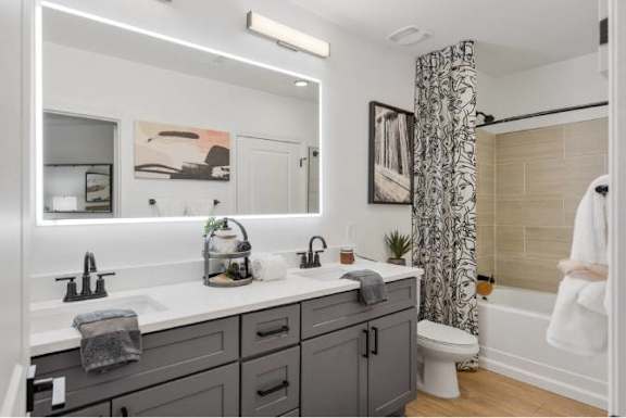 A bathroom with a white countertop and a white toilet.