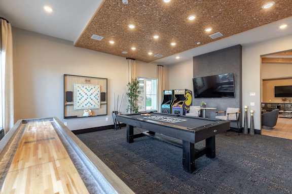 A room with a long wooden table and a television on the wall.