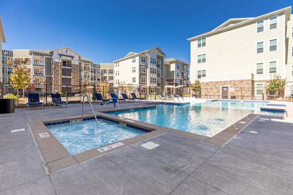 A swimming pool in a residential area surrounded by buildings.