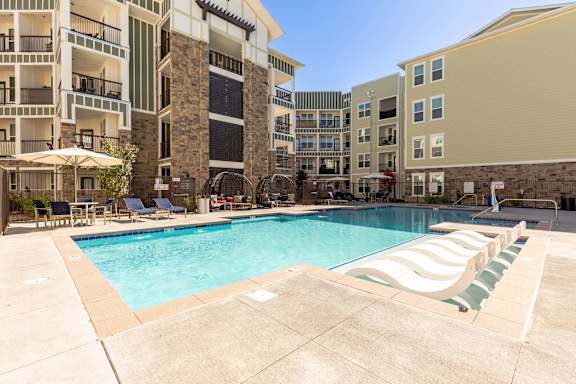 A large swimming pool in front of apartment buildings.