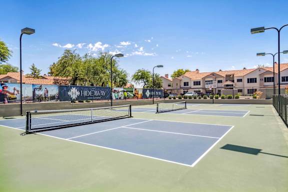 A tennis court with a banner that says "HIDEAWAY" on it.