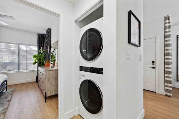 A modern laundry room with a washer and dryer built into the wall.
