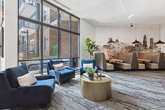 A living room with blue couches and a large window.