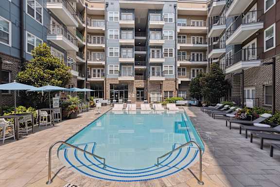 A large swimming pool in the middle of a courtyard surrounded by apartment buildings.