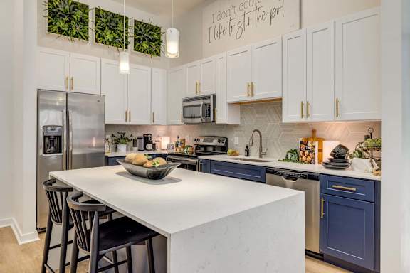 A kitchen with a white countertop and a bowl of fruit on it.
