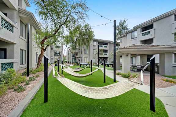 A grassy area with a white curved walkway and black poles.
