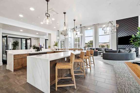 A modern kitchen with a bar area and a dining area with chairs.