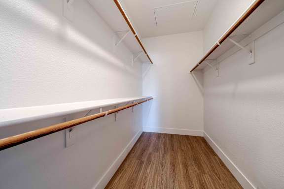 A long, narrow hallway with wooden floors and white walls.